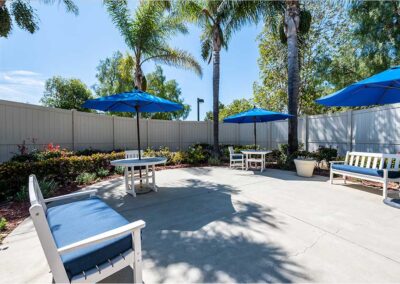 Outdoor waiting area with blue umbrella and chairs